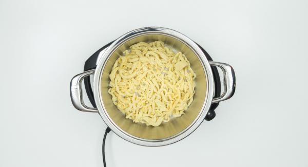 Colocar la olla en el Navigenio. Verter agua en la olla. Añadir los fideos, la cebolla y el queso, por ese orden.