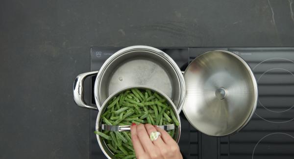 Verter agua (unos 200 ml) en una olla. Colocar las judias en la Softiera e introducirla en la olla.