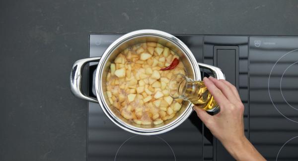 Añadir la manzana, la pera y la guindilla, desglasar con Calvados o ron y dejar evaporar. Agregar el vino y el zumo de manzana, hervir todo hasta que esté cremoso. Retirar la guindilla al final.