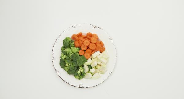 Limpiar las verduras, cortarlas en trozos iguales y ponerlas en la olla mojadas. Cortar las cebolletas y añadirlas.