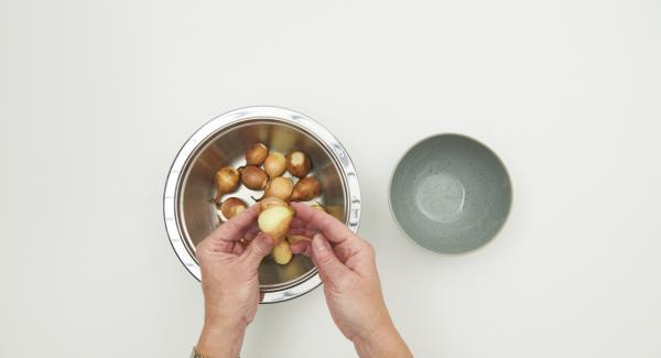 Cortar la raíz de las cebollas y colocarlas en un bol. Verter agua hirviendo sobre ellas, dejar reposar durante aproximadamente 1 minuto, escurrir, pelar y cortar por la mitad.