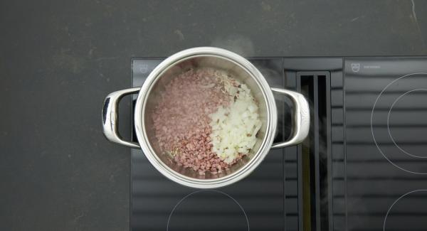 Cuando el Avisador emita un pitido al llegar a la ventana de “chuleta”, bajar la temperatura, añadir los dados de bacon y freír. Incorporar la cebolla y freír.