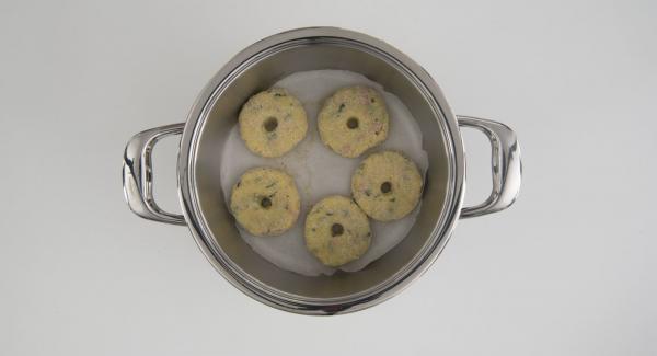 Cuando el Avisador emita un pitido al llegar a la ventana de “chuleta”, retirar y colocar la olla en su tapa. Colocar el papel de hornear dentro de la olla. Introduzca las rosquillas de masa. Colocar el Navigenio en modo de horno (poniéndolo invertido encima de la olla) y ajustar a temperatura baja. Cuando el Navigenio parpadee en rojo/azul, introducir 30 minutos en el Avisador y hornear.