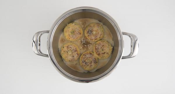 Cuando el Avisador emita un pitido al finalizar el tiempo de cocción, espolvorear las rosquillas con el queso parmesano restante. Ajustar a temperatura media. Cuando el Navigenio parpadee en rojo/azul, introducir 1 minuto en el Avisador y gratinar hasta obtener el crujiente deseado.