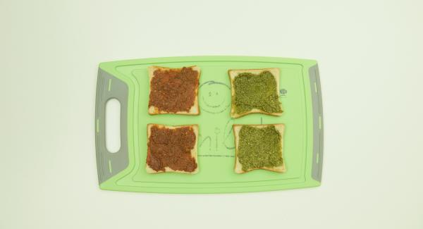 Untar la mitad de las rebanadas de pan con el pesto rojo o verde. Añadir el gouda o la mozzarella y el jamón dulce o salami y colocar una rebanada encima.