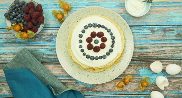 Extender los panqueques y cubrir cada uno de ellos con parte de la masa cremosa. Colocarlos uno encima del otro. Servir la torta de panqueques adornada con el resto de la masa cremosa y las frutas frescas.