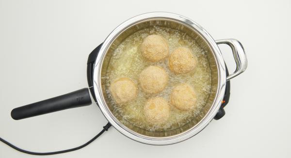 Cuando el Avisador emita un pitido al llegar a la ventana de “chuleta”, bajar temperatura de Navigenio nivel 3. Incorpora las bolas de arroz, tapar y freír. Con la ayuda del Avisador, freír hasta alcanzar los 90ºC. Dar la vuelta a las bolas y freír hasta que estén doradas, retirar y dejarlas escurrir sobre papel de cocina.