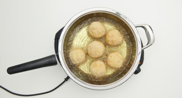 Cuando el Avisador emita un pitido al llegar a la ventana de “chuleta”, bajar temperatura de Navigenio nivel 3. Incorpora las bolas de arroz, tapar y freír. Con la ayuda del Avisador, freír hasta alcanzar los 90ºC. Dar la vuelta a las bolas y freír hasta que estén doradas, retirar y dejarlas escurrir sobre papel de cocina.