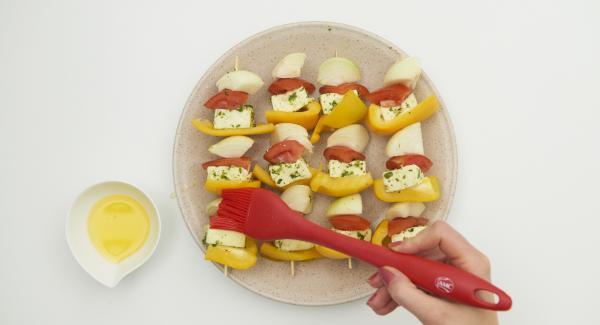 Colocar todas las verduras preparadas y los dados de tofu alternativamente en cuatro brochetas de madera. Con un pincel, pintar las brochetas con la mantequilla derretida.