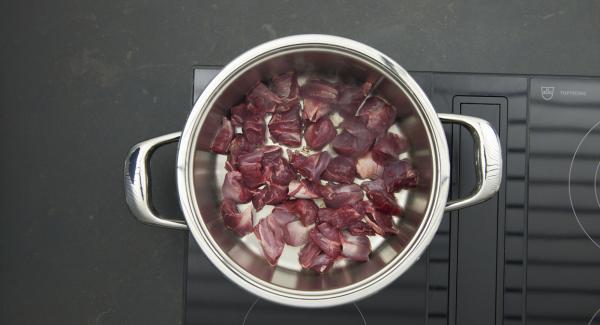 Cuando el Avisador emita un pitido al llegar a la ventana de “chuleta”, bajar la temperatura y añadir la carne cortada en trozos, dorar por los dos lados, retirar y sazonar con sal y pimienta.