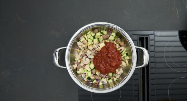 Quitar la tapa, voltear la carne. Añadir las verduras y asar brevemente. Añadir los tomates y el caldo.