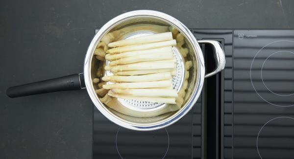 Introducir los espárragos blancos en la HotPan 28 cm a temperatura máxima. Encender el Avisador, introducir 15 minutos de tiempo de cocción. Colocarlo en el pomo y girar hasta que se muestre el símbolo de “zanahoria”. Cuando el Avisador emita un pitido al llegar a la ventana de “zanahoria”, bajar la temperatura y cocer hasta el final.