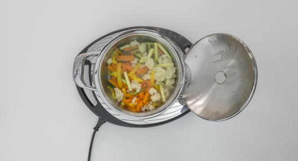 Cuando el Avisador emita un pitido al finalizar el tiempo de cocción, extender la mezcla crujiente sobre las verduras y colocar la olla en la tapa invertida.