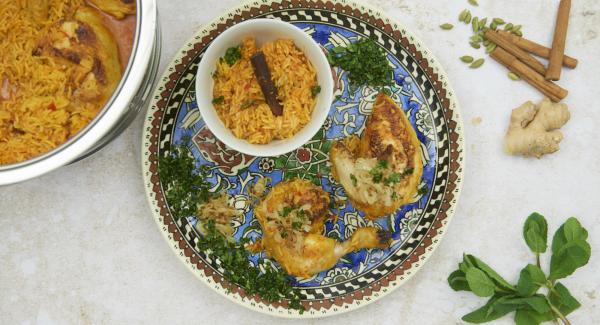 Picar finamente las hojas de cilantro y las de menta. Servir el pollo junto con el arroz, las hierbas y la cebolla.