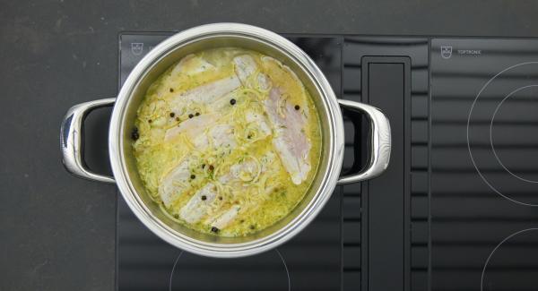 Cuando el Avisador emita un pitido al llegar a la ventana de “verdura”, bajar la temperatura y colocar los filetes de pescado en la olla. Inclinar ligeramente la olla para que el pescado blanco quede cubierto con la marinada.