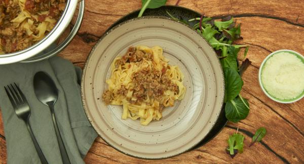 Finalizado el tiempo de cocción, escurrir la pasta. Mezclar los tallarines con la salsa boloñesa, espolvorear el parmesano y servir.