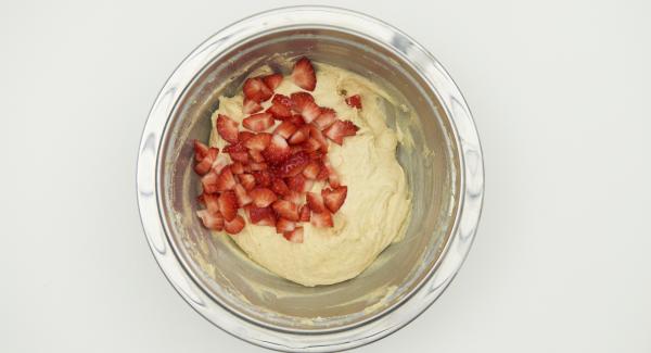 En un bol, añadir la harina, la levadura y remover brevemente. En el bol de la mezcla de la mantequilla y el azúcar batidos, incorporar la nata, la mezcla de la harina y remover. Agregar las fresas y mezclar.