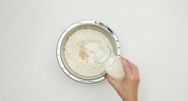 En un bol, introducir la harina. En el centro, añadir la levadura fresca desmenuzada. Añadir el azúcar y la leche en el centro y mezclar con cuidado. Cubrir y dejar reposar 20 minutos.