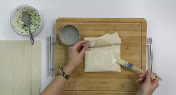 Colocar 2 láminas de masa, una encima de la otra. Esparcir un poco de queso de oveja por encima. Doblar el lado derecho, y luego, doblar el lado izquierdo *ver foto. Fijarlo con un poco de agua.