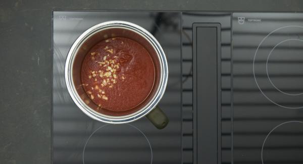 Pelar y cortar el ajo en dados finos y cortar el queso gorgonzola en trozos. En una olla pequeña, agregar el ajo y los tomates.  Colocar la olla en el fuego a temperatura máxima. Encender el Avisador (Audiotherm), colocarlo en el pomo (Visiotherm) y girar hasta que se muestre el símbolo de “zanahoria”.