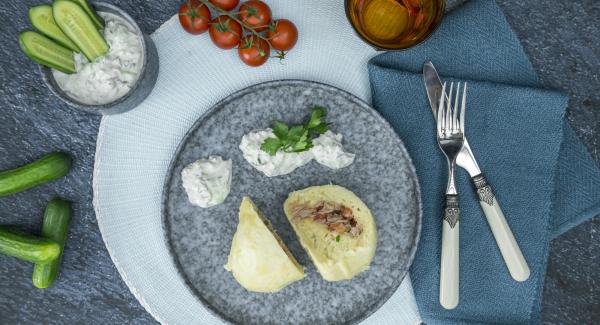Para el acompañamiento, lavar el pepino. Cortarlo a trozos de unos 4 cm y trocearlo con el Quick Cut. Quitar las hojas de las hierbas, añadirlas y volver a picarlo todo. Agregar el yogur y sazonar con sal y pimienta.