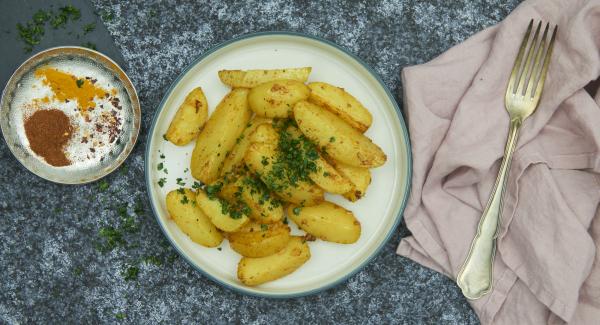 Picar finamente el perejil fresco y espolvorear sobre las patatas asadas y servir.