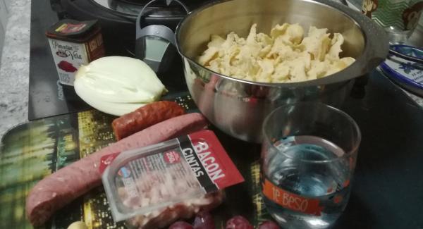 Preparar el pan cortarlo finito o bien emplear una migas  ya cortadas  y ponerlas a remojo salpicando con la mano  con el medio vaso de agua y preparar el resto de ingredientes