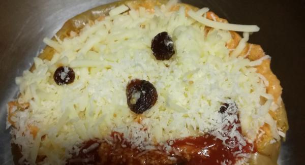 Pondremos el queso mozzarela y parmesano por encima  y le pondremos unas pasas haciendo el dibujo de la cara y un poquito de tomate frito en la boca