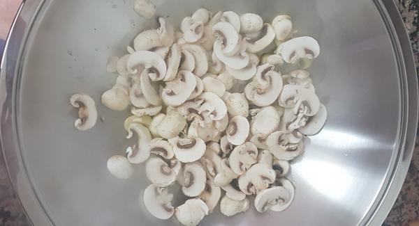 Ponemos aceite en el wok que serán una 3-4 cucharadas. Añadimos el ajo picado,la guindilla y la almendra.  Tapamos. Poner el avisador en casilla Chuleta . Encender Navigenio al 6. Cuando avise que ya ha llegado a símbolo Chuleta, añadir el champiñon, dar unas vueltas que se dore un poquito . Tapar unos minutos.