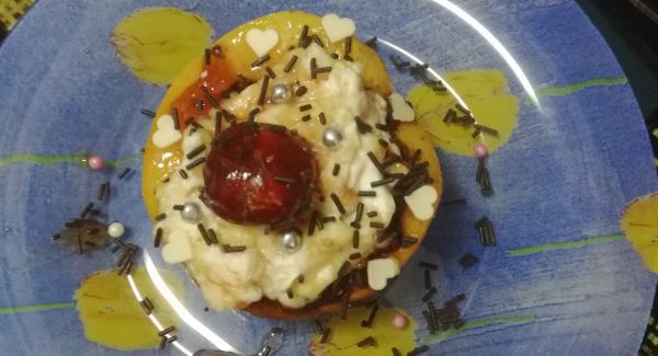 Cuando hayan transcurrido los doce minutos sacaremos los melocotones a un plato y procederemos a rellenarlos con la masa preparada , después pondremos una cereza encima de cada melocotón y salsearemos con el almíbar resultante de las cerezas y las uvas que habrá reducido lo echaremos por encima de los melocotones así tendremos un plato listo