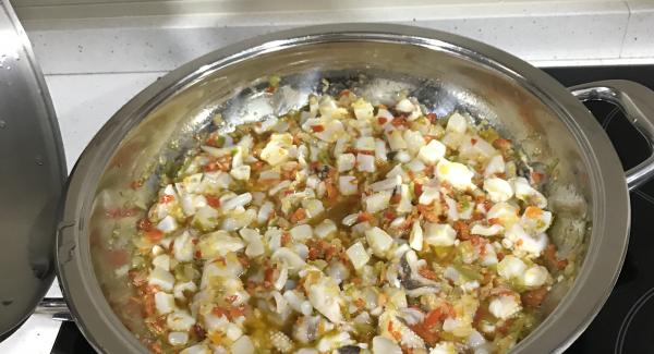 Freímos la cebolla, ajos, pimientos, picados en trozos pequeños. A continuación añadimos la jibia troceada en trocitos pequeños también. Sofreímos bien.